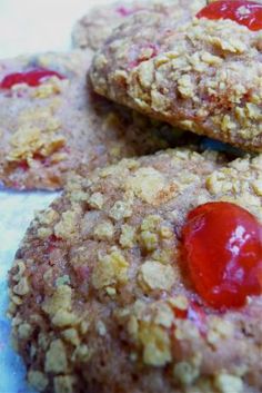 three cookies with cherries on them sitting on a table