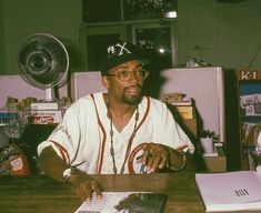 a man sitting at a desk in front of a laptop computer and magazine on the table