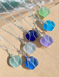 five sea glass hearts are hanging from a chain