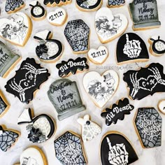 decorated cookies with black and white designs are on a table next to each other in the shape of tombstones