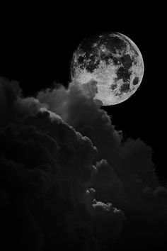 black and white photograph of the moon with clouds