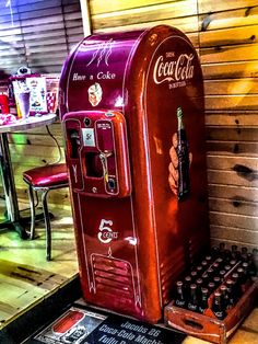 an old fashioned coca cola machine sitting on the ground