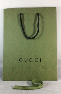 a green gucci bag with a black string on it