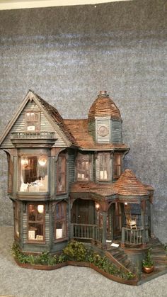 a doll house is shown with lights on the porch and stairs to the second floor