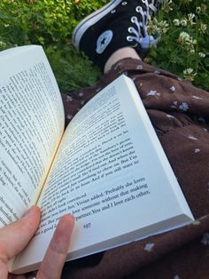 someone is reading a book in the grass