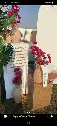 two vases with flowers are on display in front of a large mirror that says repurfy to dola alohher