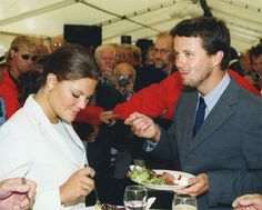 a man and woman eating food at an event