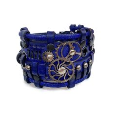 This blue leather bracelet looks absolutely stunning. It is designed for men and women who love steampunk or cyberpunk fashion trends.  It was made of genuine leather and decorated with metal parts Bracelet's width is about 2 in (5 cm) Bracelet's length is about 7.9 in (20 cm) It fits the wrist 7.1-8.3 in (19-22 cm) Please measure your wrist to make the correct choice  IMPORTANT - since it's a handmade item there might be slight variations in the design, however, the general idea and impression will be preserved. CARE No special care is required. Avoid chemical exposure including perfumery. If you need a custom order please let me know and I will try to do my best to prepare it for you:) If you have any questions feel free to ask.  Thank you for choosing shop Steampunk Adjustable Bracelets For Festivals, Blue Leather Bracelets For Festival, Blue Leather Festival Bracelets, Adjustable Steampunk Festival Bracelets, Adjustable Steampunk Bracelets For Festivals, Adjustable Blue Leather Bracelet For Festivals, Leather Punk Cuff Bracelet For Festival, Adjustable Blue Leather Cuff Bracelet, Steampunk Leather Bracelet As A Gift