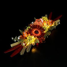 a bunch of flowers that are sitting on a table with some lights in the background