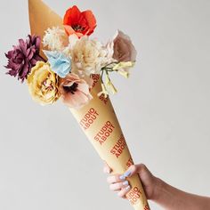 a person holding a flower bouquet in their hand with the words you're so beautiful written on it