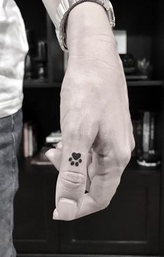 a person with a small tattoo on their left hand holding the finger of another person