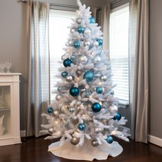 a white christmas tree with blue and silver ornaments