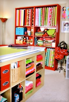 a sewing room with lots of crafting supplies on the shelves and storage bins