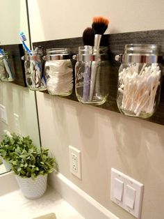 the bathroom is decorated with mason jars and toothbrushes, along with other items