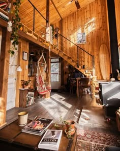 a living room filled with furniture and a wooden staircase leading up to the top floor