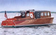 a red and brown boat with an american flag on it's side in the water