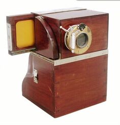 an old fashioned wooden box with a yellow object in the front and side view mirror on top