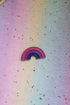 a rainbow sticker sitting on the side of a wall next to confetti