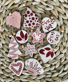 some red and white ornaments sitting on top of a wicker basket next to nuts