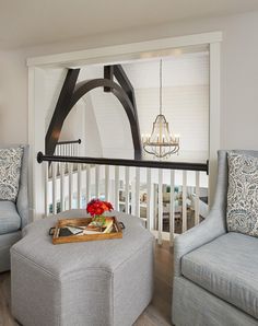 a living room filled with furniture and a chandelier hanging over the top of it