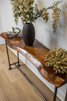 two vases with flowers are sitting on a wooden table