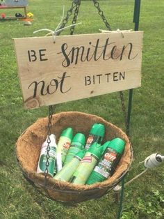 a sign that says be smitten not bitten in front of some green bottles