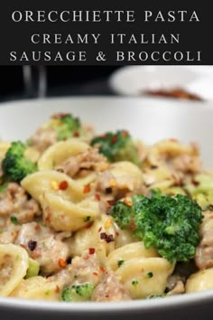 pasta with sausage and broccoli in a white bowl on top of a table