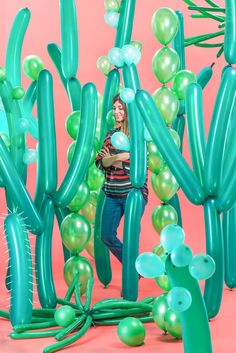 a woman standing in front of giant green and white balloons