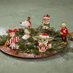 a group of figurines sitting on top of a metal tray covered in snow