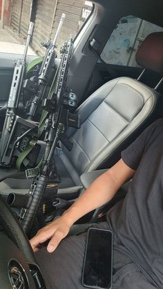 a man sitting in the driver's seat of a vehicle holding a cell phone