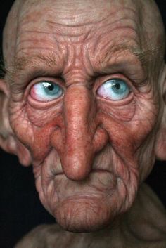 an old man's face with blue eyes and wrinkles on the upper half