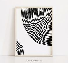 a black and white art print with wavy lines on it's back side in a frame