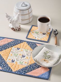 two placemats, one with a bird on it and the other with a cup of coffee