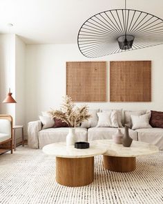 a living room with two couches and a coffee table in front of the wall