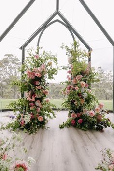 an outdoor ceremony with flowers and greenery on the floor, set up in a tent