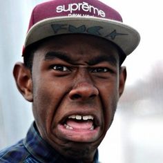 a black and white photo of a man wearing a supreme hat