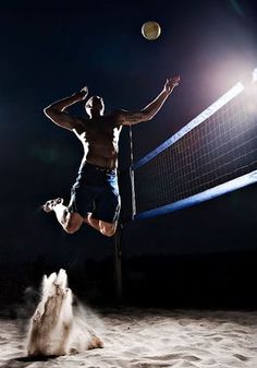 a man jumping up to hit a volleyball