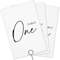 three cards with the word table one on them and a pair of scissors in front