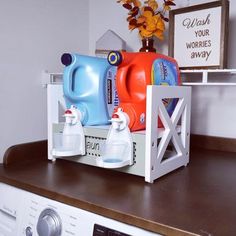 a washer and dryer sitting on top of a wooden shelf next to each other