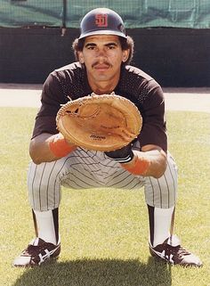 a baseball player holding a catchers mitt in front of his face with the words padres on it