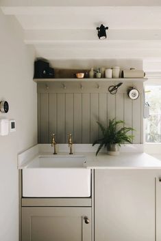 a white kitchen sink sitting under a window