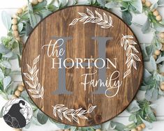 a wooden sign that says i love the horton family with leaves and berries around it