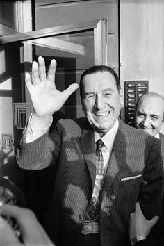 a black and white photo of a man waving