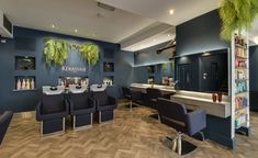 the interior of a salon with blue walls and chairs