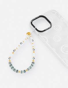 a cell phone case with a beaded lanyard attached to the back of it