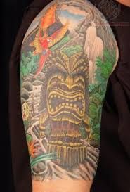 a man with a tiki tattoo on his arm