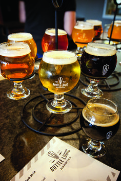 five different types of beer are lined up on a table with menus and glasses