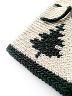 a crocheted bag with a black and white design on the front is shown