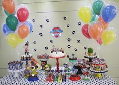 a table topped with lots of cake and balloons