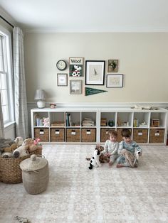 two children sitting on the floor with stuffed animals